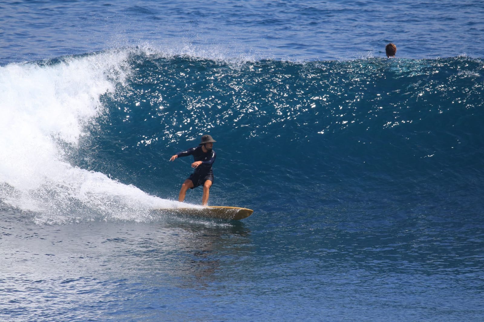 Simon surfing a hollow blue wave